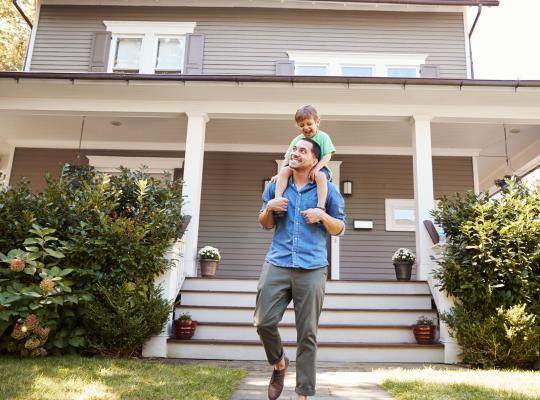 father and son in front of home